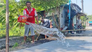 Warga Siram Jalan, Wujud Kepedulian Tuntasnya Sasaran Fisik TMMD 121 Mojokerto